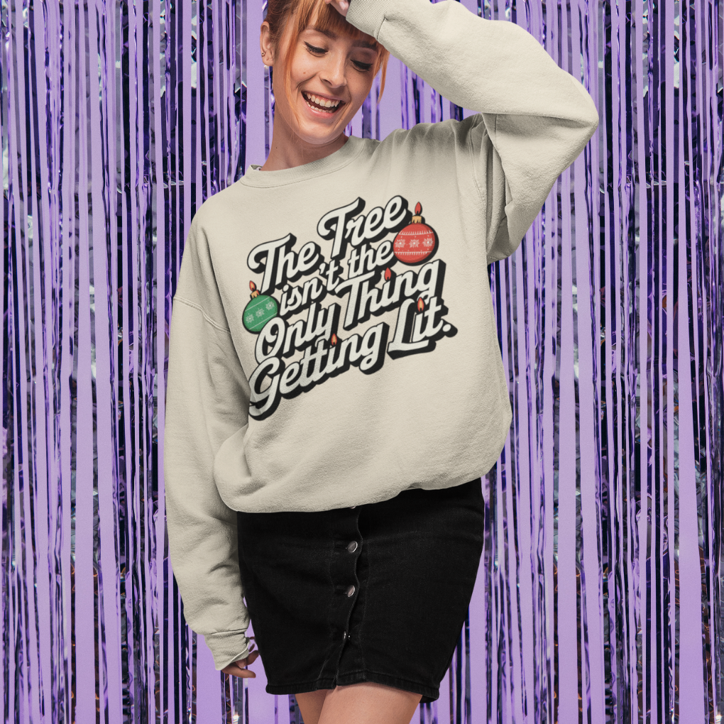 Person wearing a sweatshirt with text and graphics against a purple tinsel background
