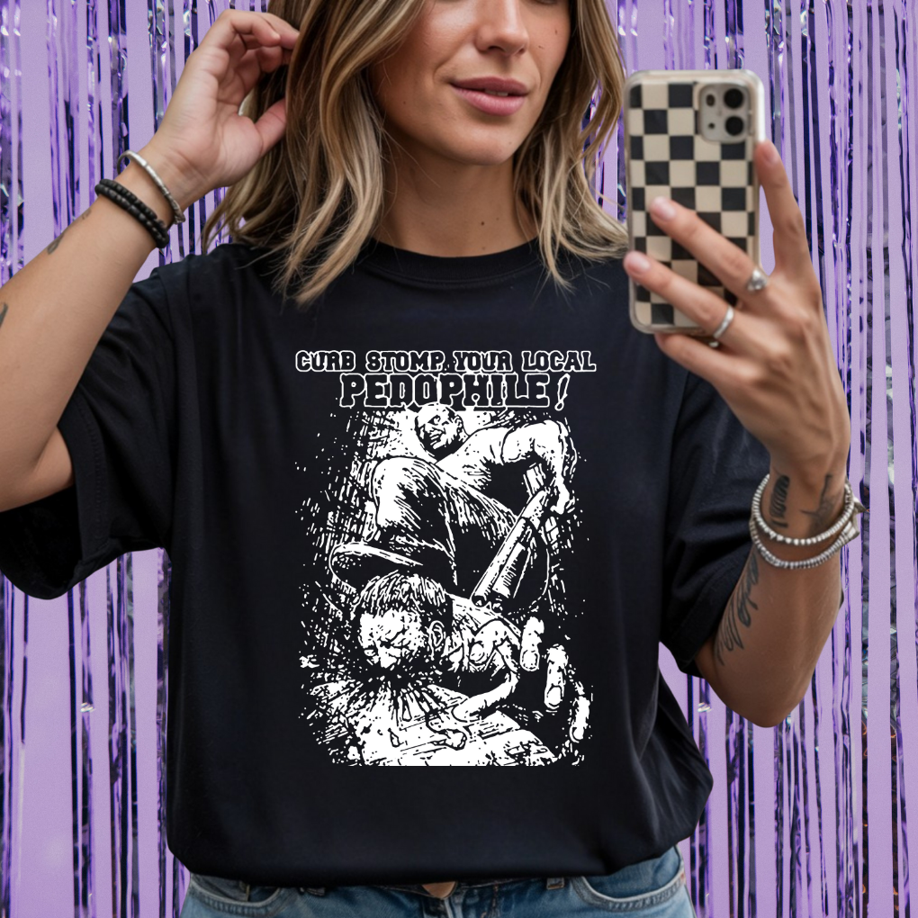 Person wearing a black t-shirt with graphic design and text, taking a selfie against a purple curtain background.